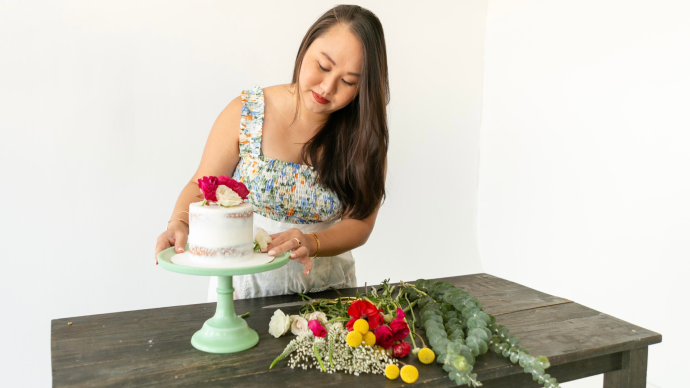 Annie Vu decorates a cake on a cake stand